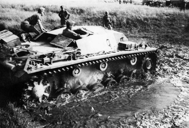 A German Sturmgeschütz III (Stug III) Ausf. B. tank slogs through thick mud and marshy terrain on the march to Leningrad.