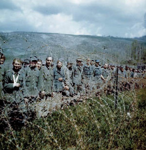 Some of the thousands of prisoners taken during the spring offensive of the Allied Fifth Army in Italy in 1945 gaze from behind a temporary enclosure of barbed wire. These were some of the lucky ones, as German casualties mounted during the last days of the war.