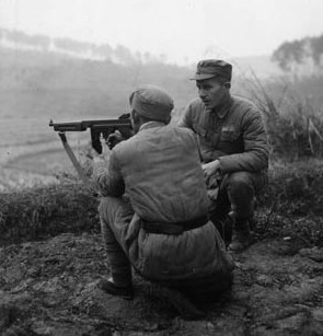 Under the watchful eye of Captain Walter Mansfield, a Chinese soldier masters the firing of a Thompson submachine gun on January 15, 1945.