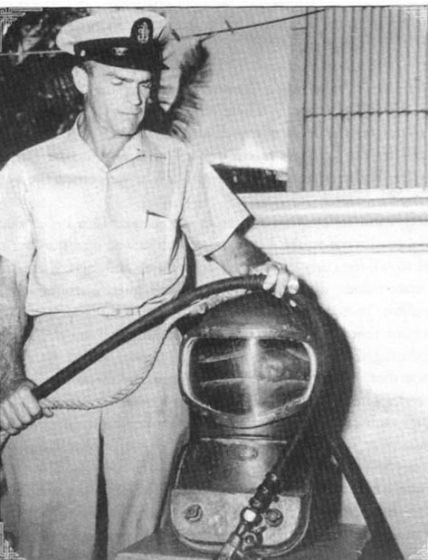 One of the U.S. Navy divers who worked to salvage the Filipino silver in Manila Bay, Robert Sheats published his experience in a book titled One Man’s War: Diving as a Guest of the Emperor. In this photo, Sheats poses with a copy of the shallow water helmet used by the American divers.