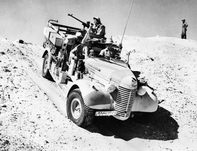 On patrol in the desert in March 1941, a truck of the Long Range Desert Group traverses a sand dune.