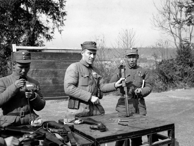 On January 25, 1945, Captain Walter Mansfield teaches a class on the Thompson submachine gun to a group of Nationalist Chinese soldiers.