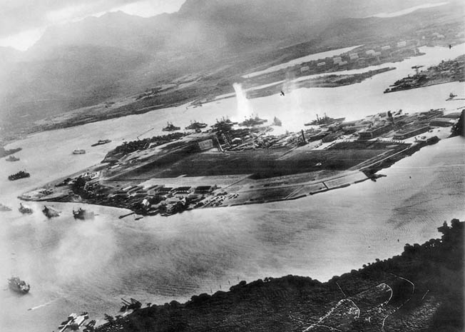 Early in the attack, a Japanese aviator captured this view of Pearl Harbor just as an explosion took place between Oklahoma and West Virginia. Visible are two Japanese planes. 