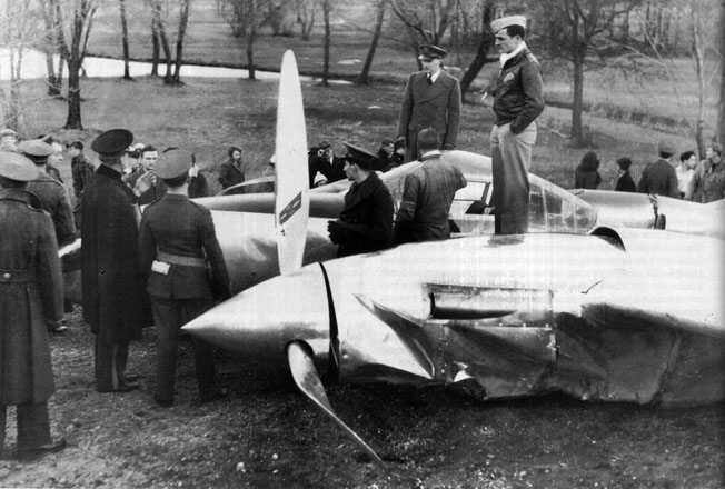 Air Force personnel and curious onlookers gather around a Lockheed XP-38 that crashed during a transcontinental flight on February 11, 1939, onto a Long Island golf course due to carburetor icing. The pilot survived. 