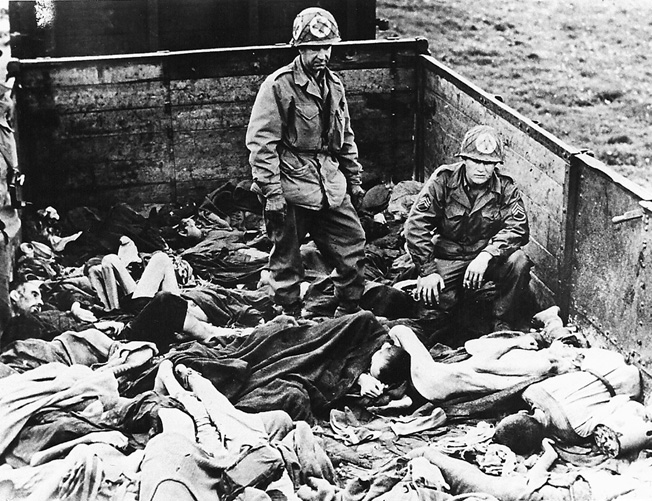 American medics check for signs of life in a railroad car left on a siding outside the Dachau concentration camp, April 29, 1945. Over 2,300 dead victims were found on the train, which had come from Buchenwald. 