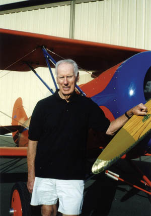 James K. Kunkle at the Santa Maria, California, airport today with a three-quarter replica of a Travel Air 4000 biplane that is one of seven aircraft he owns.