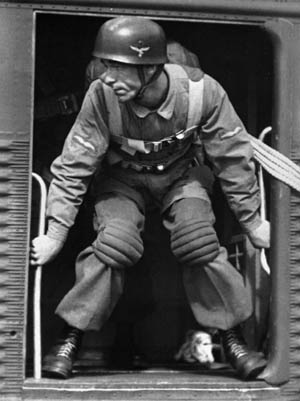 A Fallschirmjäger poses for a publicity shot in the doorway of a Ju-52. Note that the Germans were not equipped with a reserve parachute as American paratroopers were.