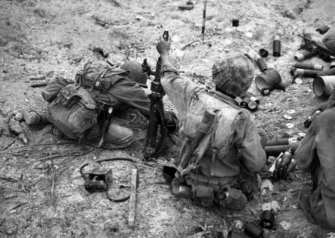 A Marine 60mm mortar crew bombards Japanese positions on Peleliu. The spent shell containers around them speak to the intensity of the fight. 