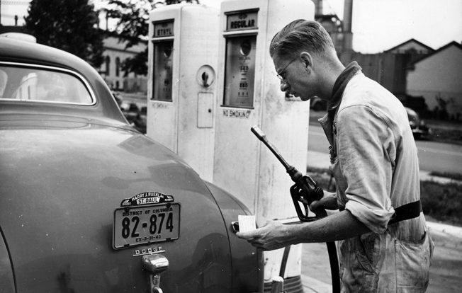 A service station attendant measures out the precious fluid in accordance with OPA’s A gasoline ration books, July 1942. 