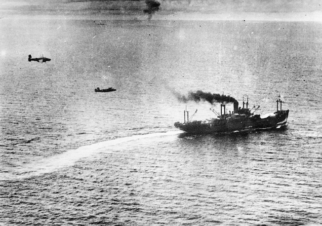 Sweeping in at mast height, a pair of U.S. medium bombers prepares to drop its payload on a Japanese merchant ship during the Battle of the Bismarck Sea.