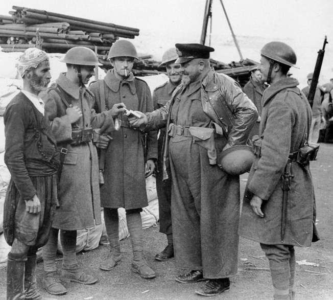 The hard-fighting Greek soldiers who participated in the defense of Crete were outfitted with a variety of uniforms and gear. Here they take a few moments in the company of an officer and a Greek civilian.