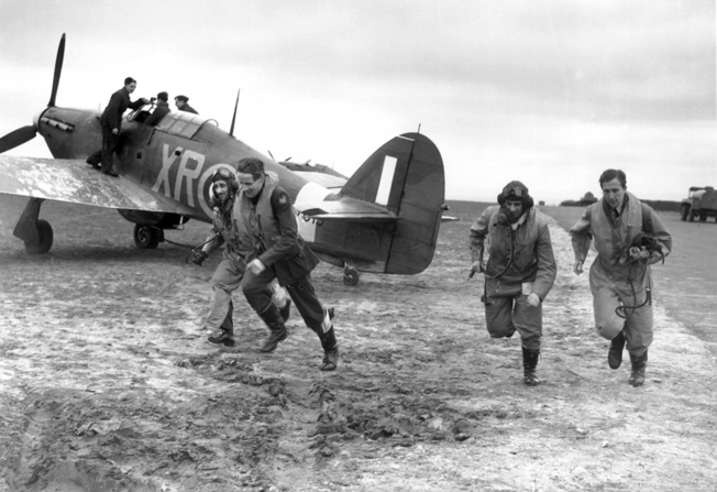 As one aviator is strapped into the cockpit of his Hawker Hurricane fighter, other pilots of the Eagle Squadron dash to the aircraft as an alarm is sounded during the Battle of Britain.