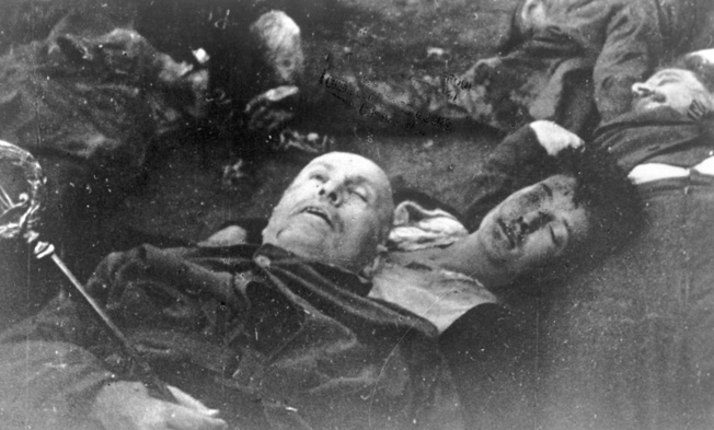 The corpses of Mussolini and his mistress Claretta Petacci, lie sprawled on the ground at the Villa Belmonte. They were later strung up in the city square of Milan.