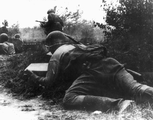 On August 12, 1942, a Red Army soldier crawls forward to deliver ammunition to comrades fighting to hold back a German counterattack on Soviet positions.