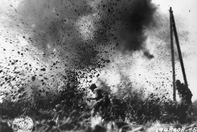 An advancing American paratrooper narrowly escapes an exploding round from a German 88mm gun. 