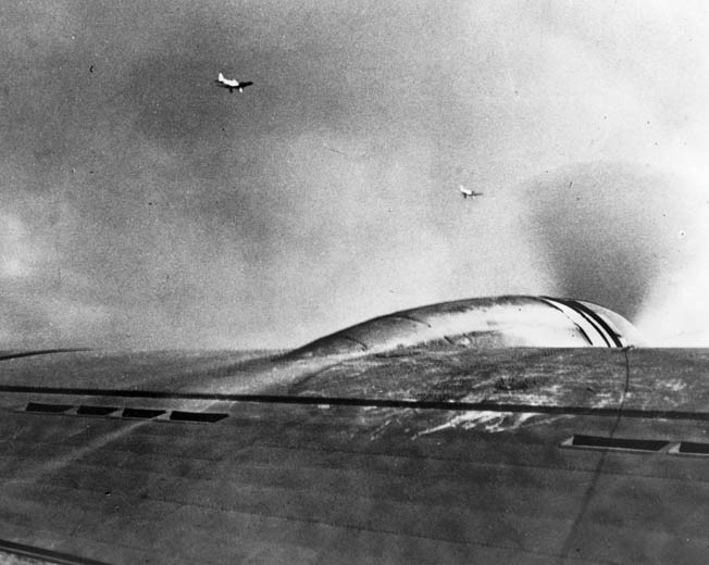 A flight of U.S. Boeing B-17 bombers from California was caught up in the air raid on Pearl Harbor. In this photo taken from one of the B-17s, a pair of Japanese Aichi D3A Val dive bombers, distinguished by their fixed landing gear, are seen heading for targets on Oahu. r