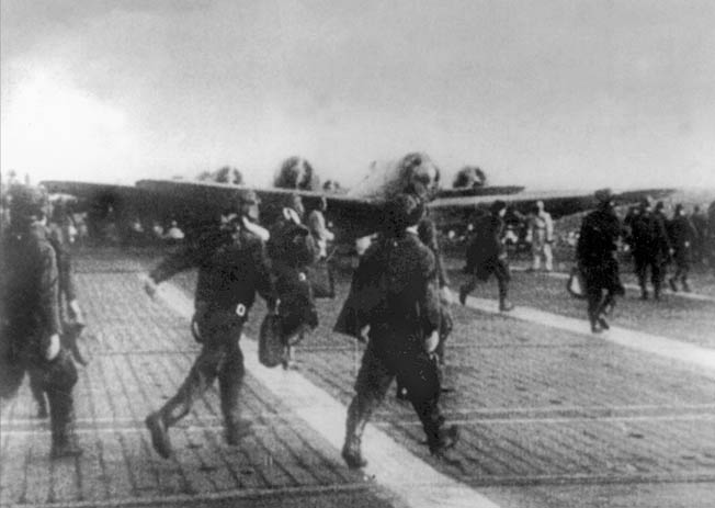 Japanese pilots rush to their planes. This photo is probably of the second wave, as the first wave took off in darkness.