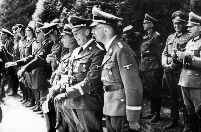 In the front row, right to left, SS Reichsführer Heinrich Himmler, chief planner of the Final Solution; Reich Chancellery head Dr. Hans Lammers; and Reich Leader Martin Bormann observe the ceremonies marking the surrender of France at Compeigne on June 21, 1940.