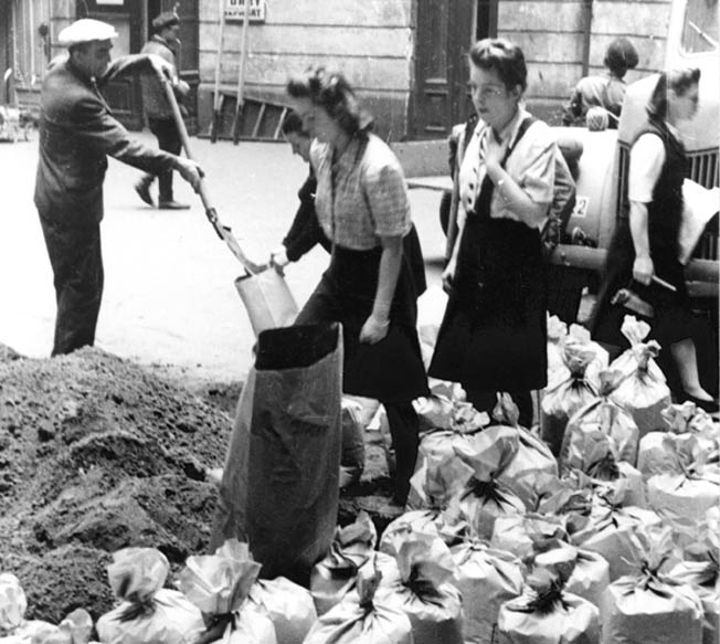 Residents of Warsaw hurriedly fill sandbags to erect a barricade on Moniuszki Street in August 1944. The Warsaw Uprising was heroic but futile as the Germans crushed the resistance with overwhelming firepower.