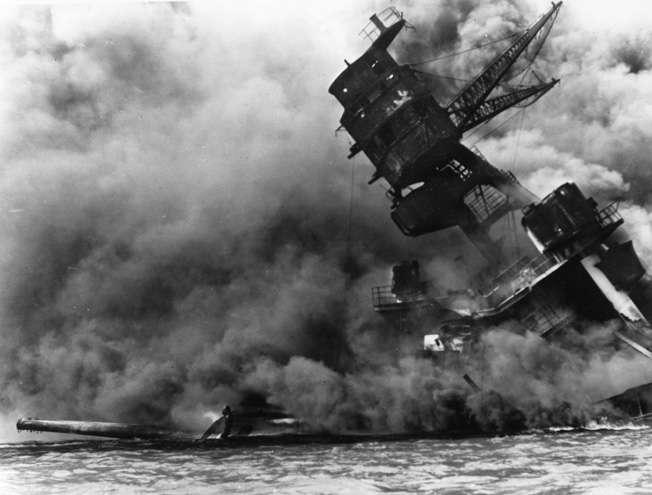 The burning battleship USS Arizona (BB-39) lists at Mooring F7 after the attack. The ship lost 1,177 men, including Rear Admiral Isaac C. Kidd, who received the Medal of Honor, posthumously.