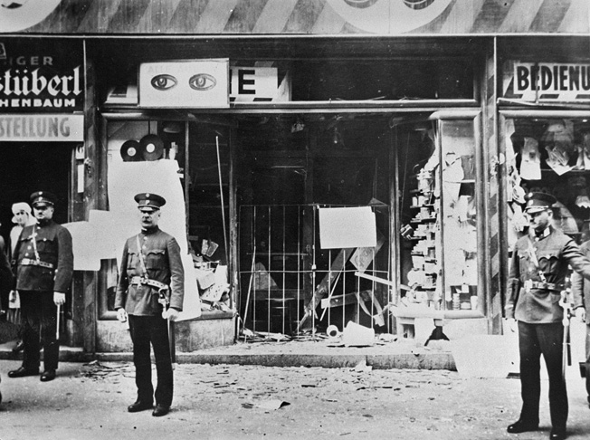 Police stand guard in front of a Jewish-owned store destroyed during Kristallnacht violence, November 1938. The Nazis assaults against the Jews were a primary factor in Karl Goldsmith's decision to leave Germany. 