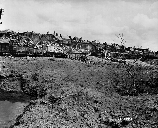The railyard in Carentan lies in ruins as a result of aerial bombing and naval shelling. Photograph taken several days after American airborne troops secured the city.