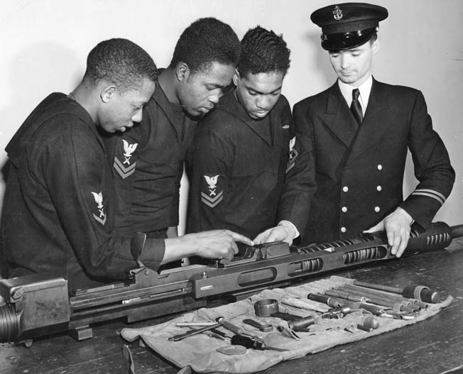 Three of the Mason’s gunner’s mates are instructed at the Norfolk Naval Training Station, Virginia, in the assembly of a 20mm machine gun—the type they will man aboard the ship. Photo taken January 3, 1944. 