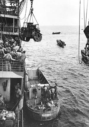 A U.S. Marine Corps M2A4 Stuart light tank is hoisted from the attack cargo ship USS Alchiba (AK-23) into a LCM(2) landing craft off the Guadalcanal invasion beaches on the first day of the landings, August 7, 1942.