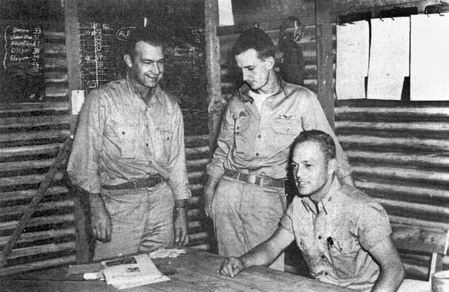 John Thompson, seated, meets with two other pilots of the 67th Fighter Squadron at the Cactus Air Force operations shack at Henderson Field on Guadalcanal. 