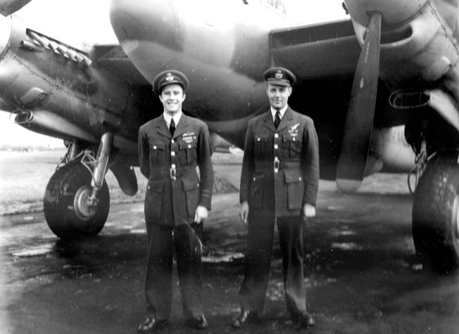 Standing in front of their Mosquito bomber, Squadron Leader Alan George, left, and navigator-observer Vivian Broad smile for a photographer. Alan George completed dozens of Pathfinder missions with Broad flying alongside.