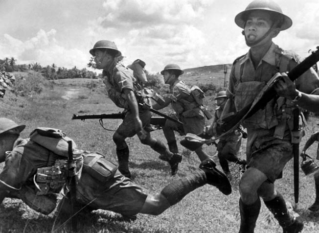Malay soldiers, equipped with British uniforms and weapons, take part in exercises in typical Malayan swamp country.