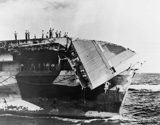 Sailors inspect the damage to the flight deck of the aircraft carrier USS Hornet after Typhoon Connie subsided. 